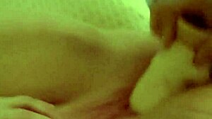 Woman inserts huge dildo into her pink pussy during solo play