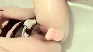 Asian lesbian solo masturbates in bath with dildo watching porn