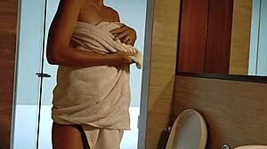 hot brunette pisses standing in clubhouse shower. steamy pee drips down sexy legs in close-up bathroom scene.