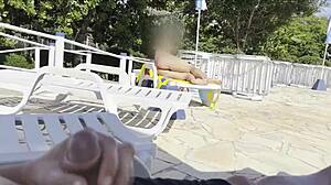 She spots guy jerking by public pool and gives handjob to help him cum outdoors