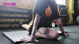 Do you see alternative girl with tattoos stretching sexy at gym?