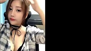 beautiful asian girl chats on phone showing big tits